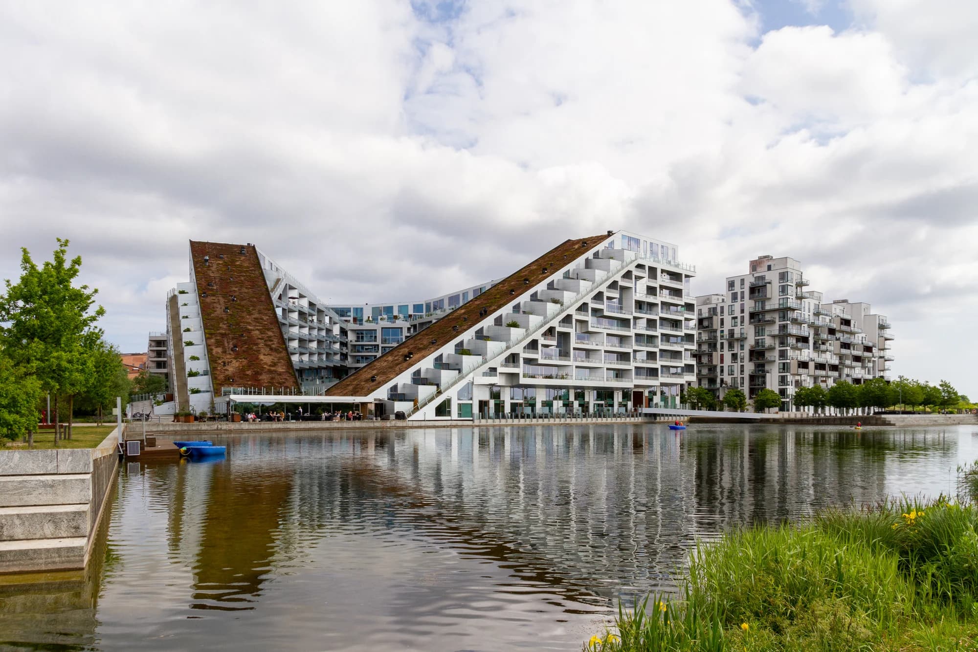 8 House in Copenhagen, with sloping planted roofs and balconies facing the water.