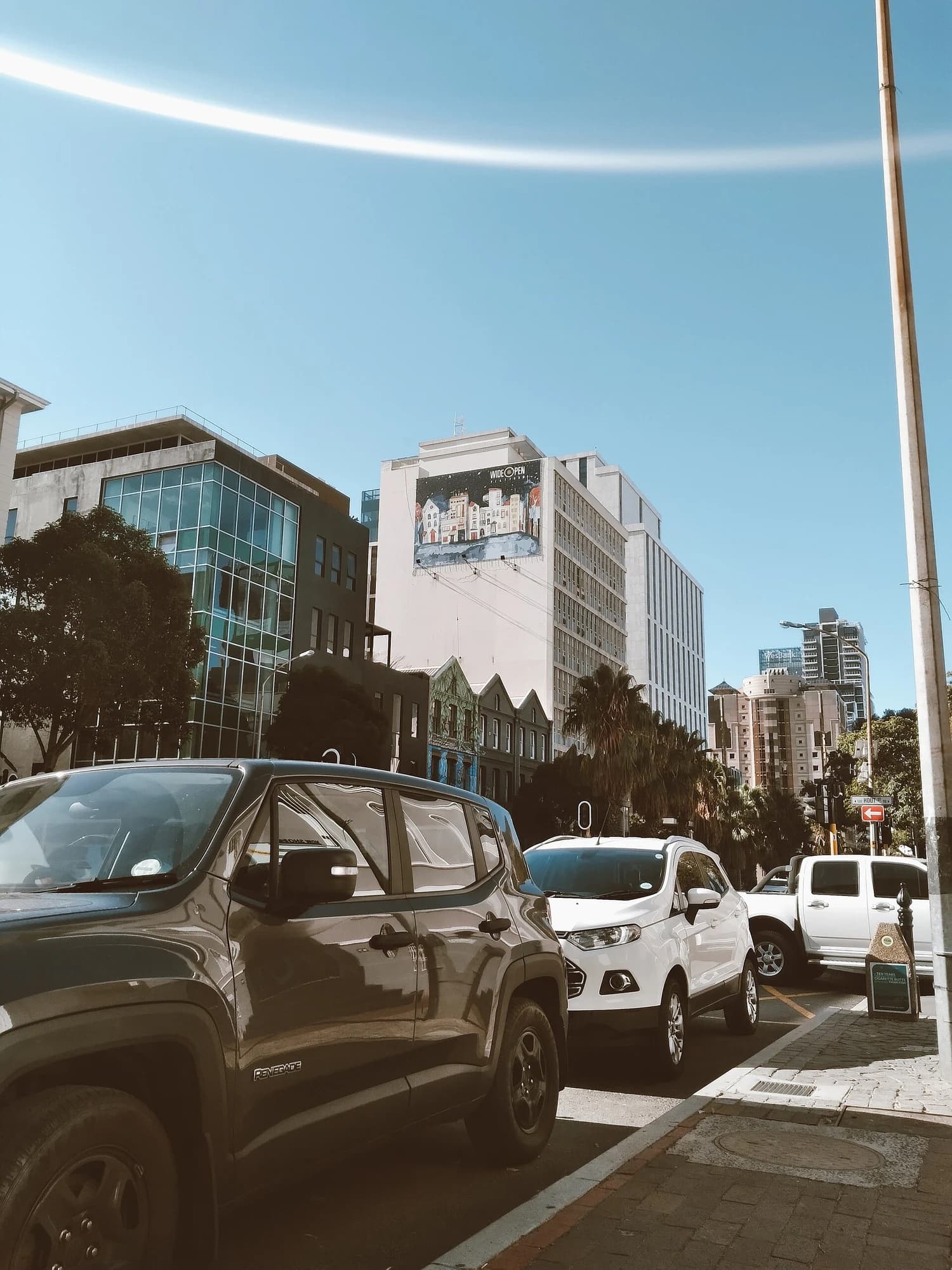 Existing buildings, parked vehicles and a pavement along Bree Street in Cape Town.